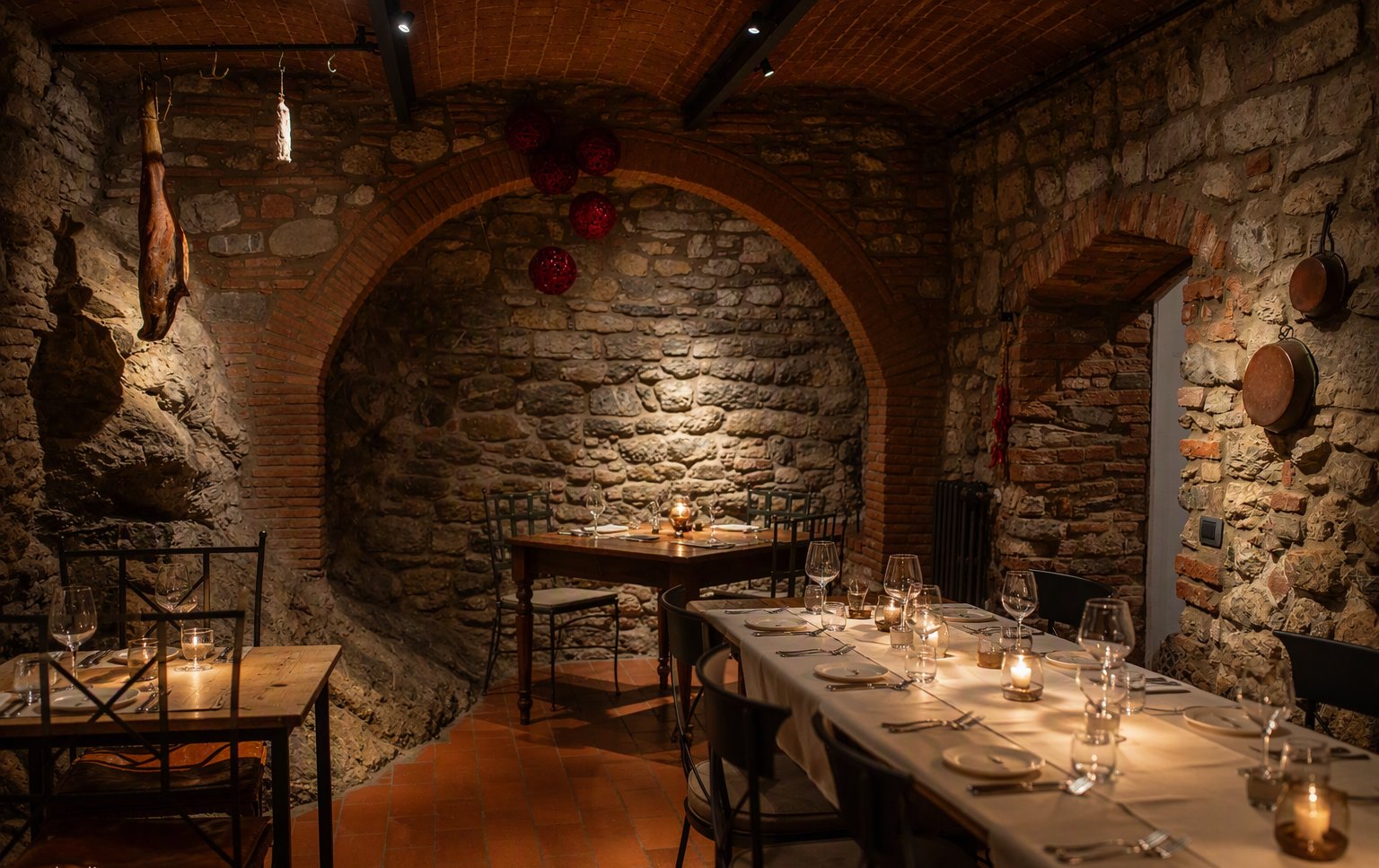 La sala voltata in pietra con la tavola apparecchiata a lume di candela