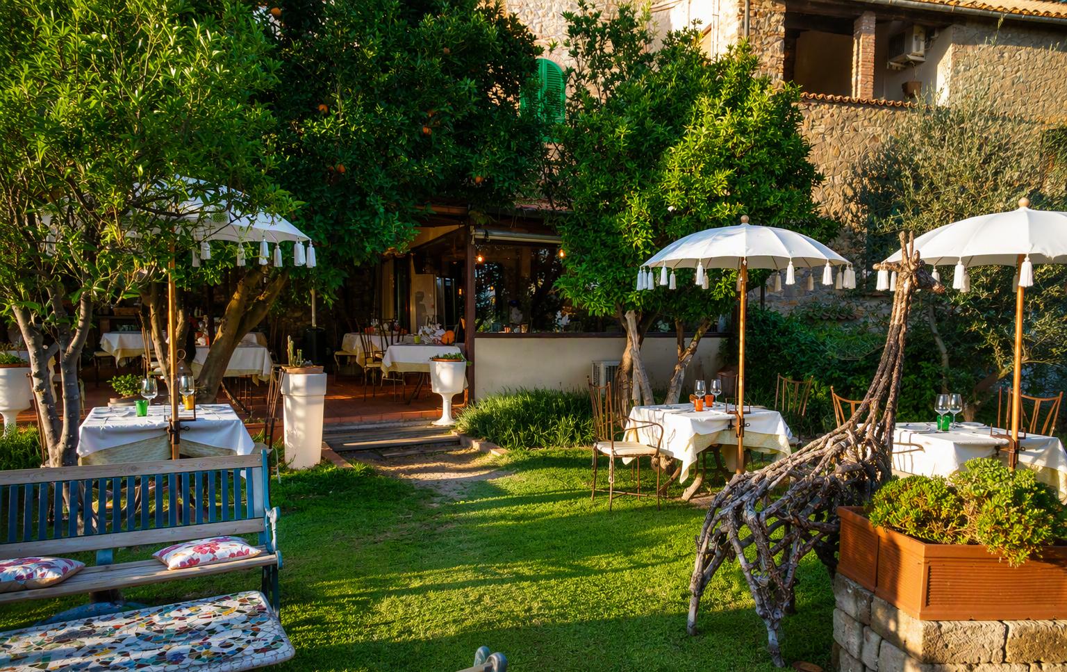 Il giardino segreto con gli ombrelloni bianchi e la scultura di giraffa